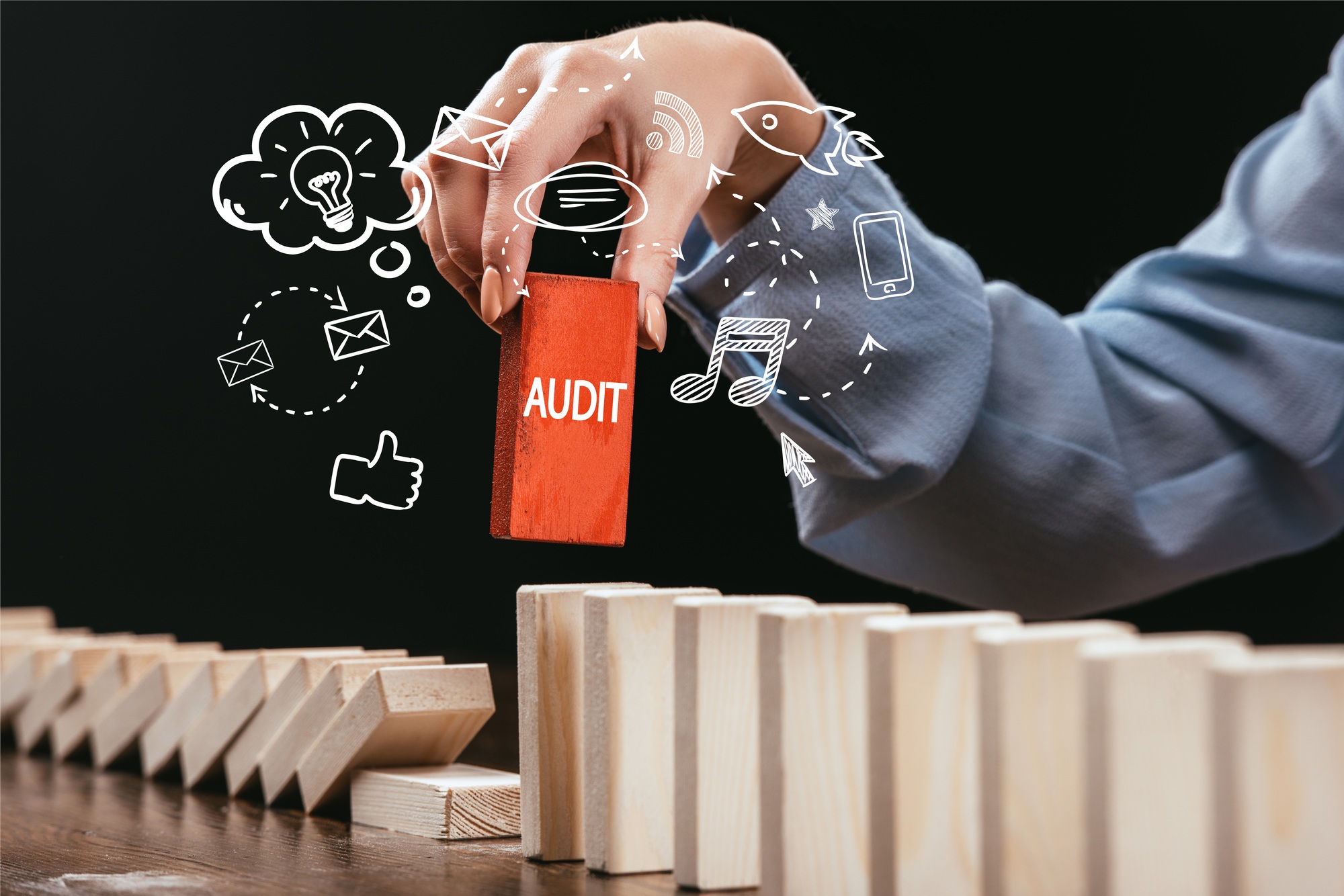 cropped view of woman picking red block with word 'audit' out of wooden bricks, icons on foreground